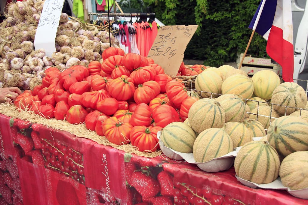 Tomates cœur de bœuf et melons sur un étal